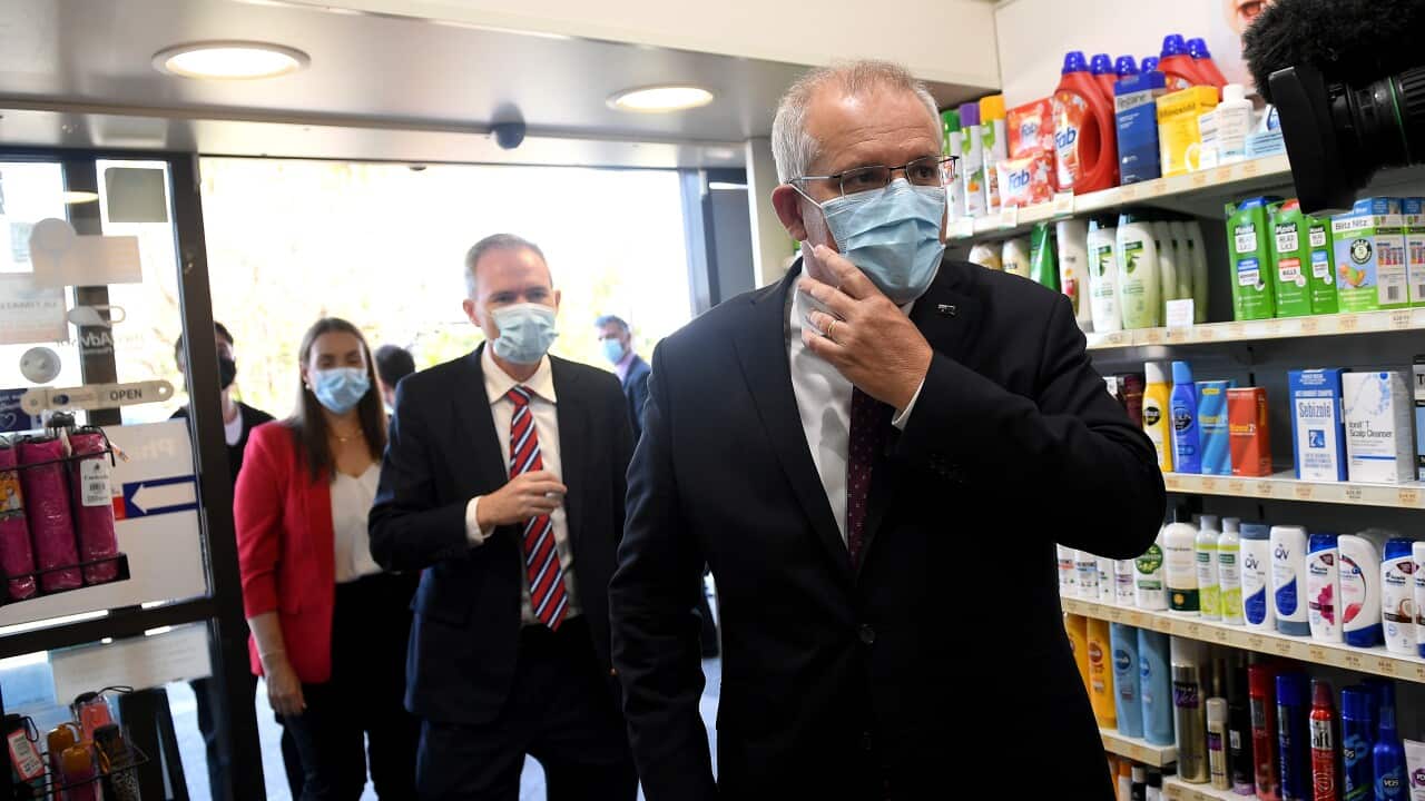 Prime Minister Scott Morrison walks into Sydney pharmacy.