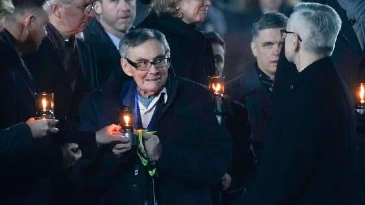 Holocaust survivor Marian Turski (C) attends a candle lighting ceremony at the former German Nazi death camp Auschwitz-Birkenau.