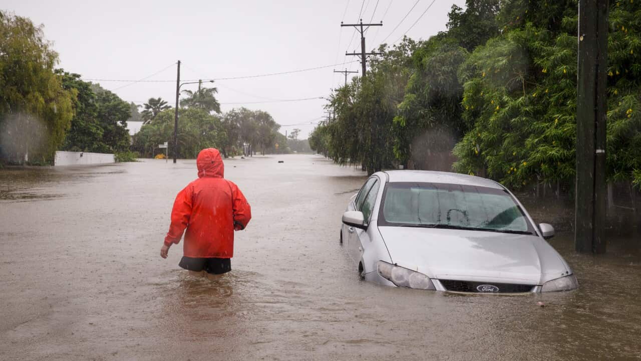 A man walks through flood water in Rosslea, Townsville, Saturday, 2 February, 2019.