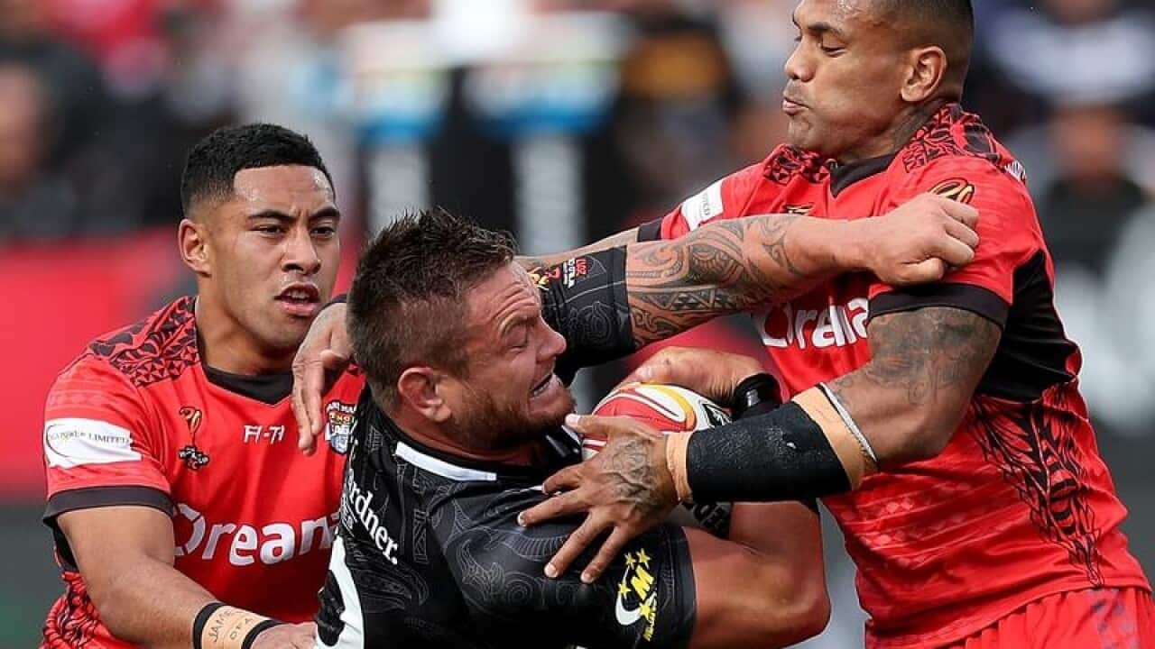 Jared Waerea-Hargreaves of New Zealand is tackled by two Tonga players