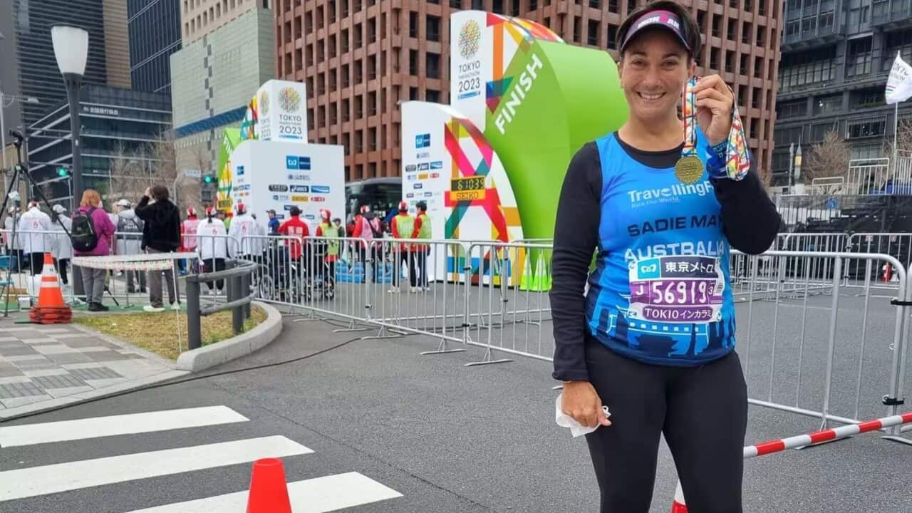 Allira Jennings holds up a medal after competing in one of the world's major marathons
