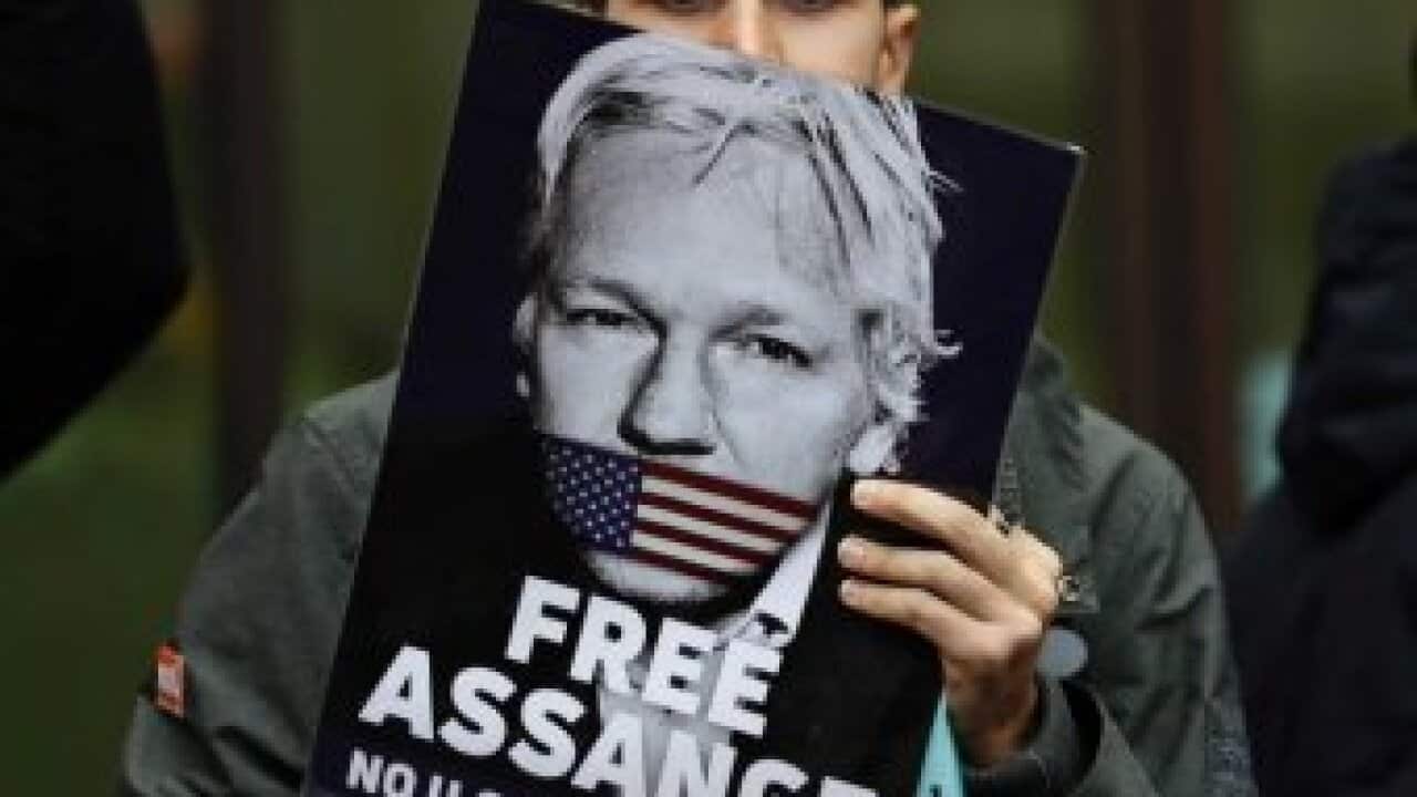 JULIAN ASSANGE SUPPORTER HOLDS A "FREE ASSANGE" PLACARD.