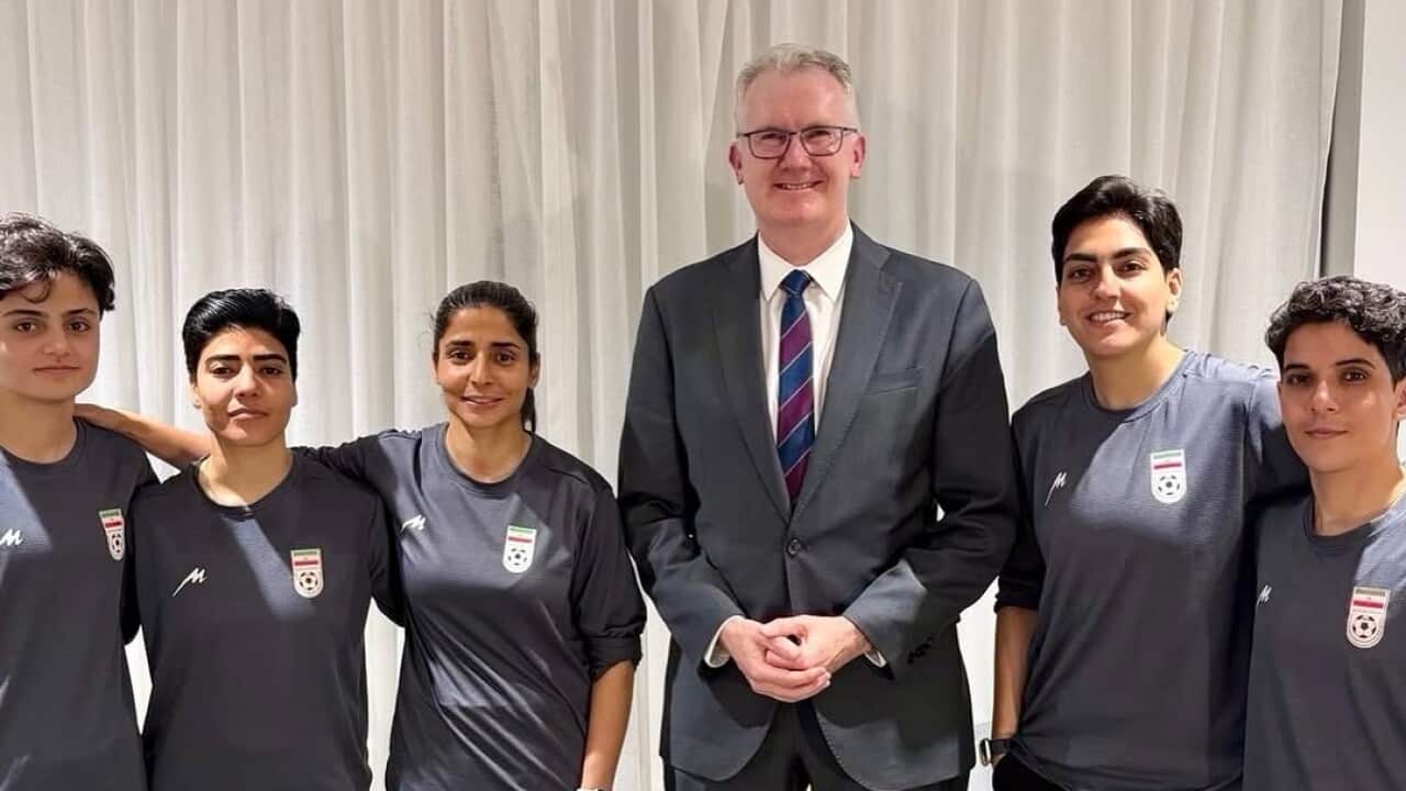 Tony Burke standing next to five women, wearing shirts with the Iranian flag and a football.