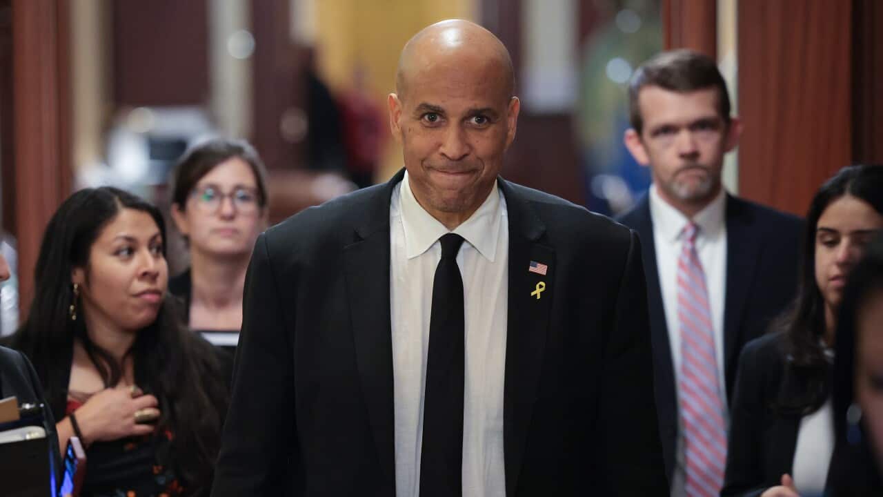 Cory Booker walks toward reporters after delivering a record setting floor speech for the US Senate