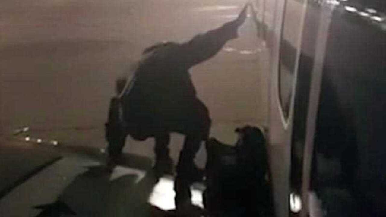 A Ryanair passenger who apparently got fed up waiting to get off a plane stands on the wing of a Ryanair plane at Malaga airport, Spain, Monday January 1, 2018, filmed by another passenger.