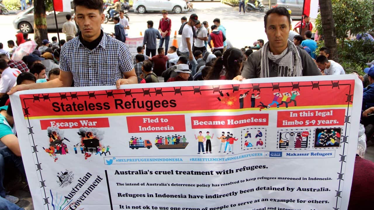 Refugees from various countries hold a banner during a protest outside the building that house the Australian Consulate in Makassar, Indonesia, Tue 20/8/2019.