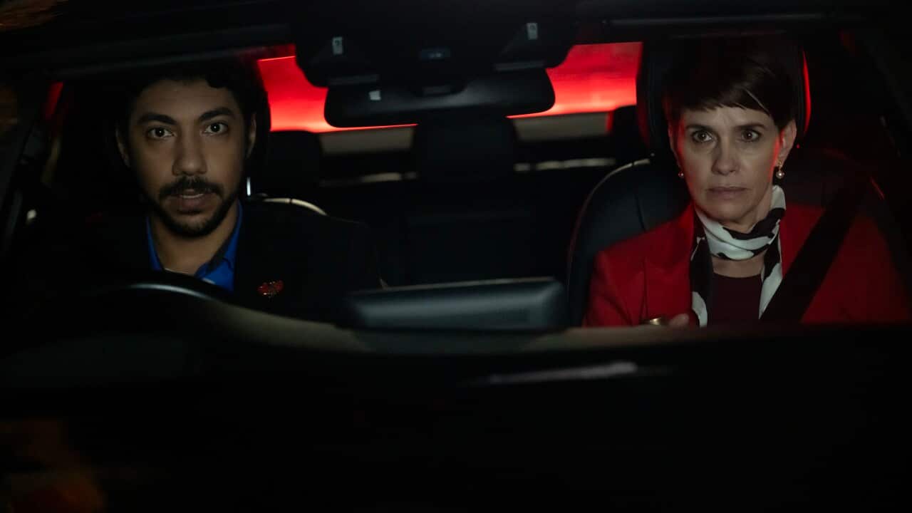 Two people in a car driving at night.