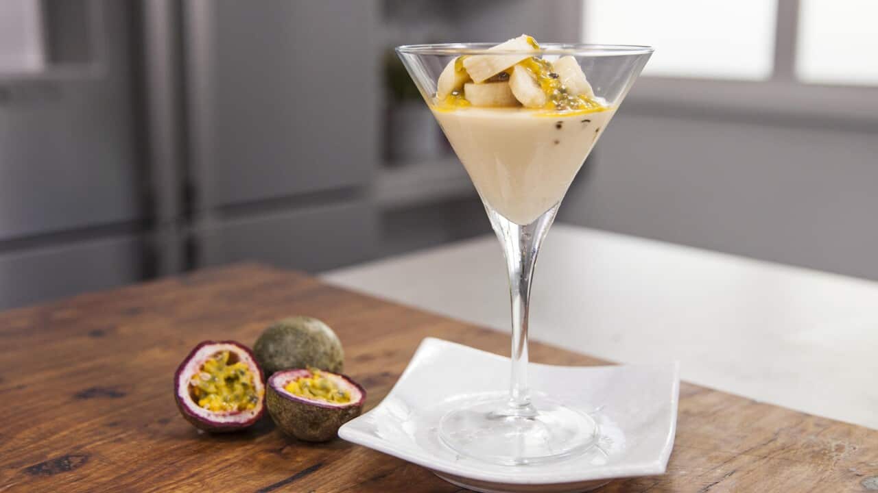 A long-stemmed glass holds a creamy mousse topped with fruit.