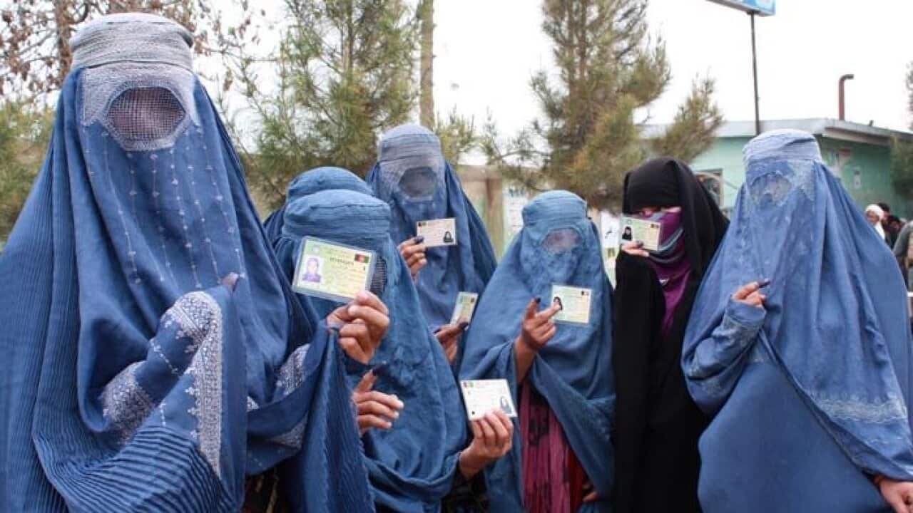Afghan women holding voting cards