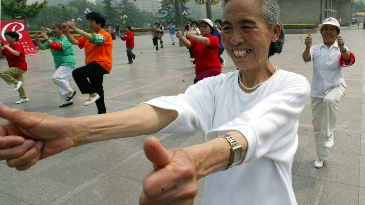 An elderly Chinese lady exercising with others at a park in Beijing, China, Wednesday, May 21, 2003. Fitness has taken on a new significance as Beijingers are encouraged to stay healthy inorder to keep SARS away. (AP Photo/Ng Han Guan)