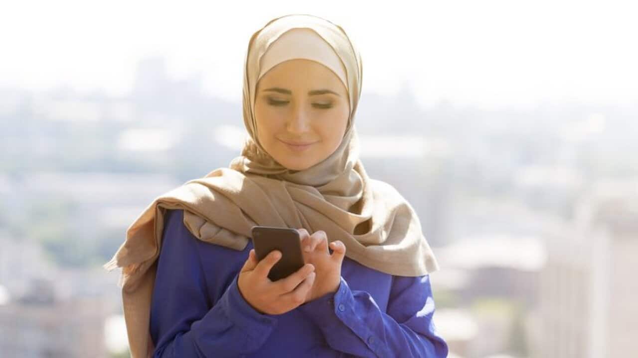 portrait of happy asian woman wearing hijab calling with mobile phone