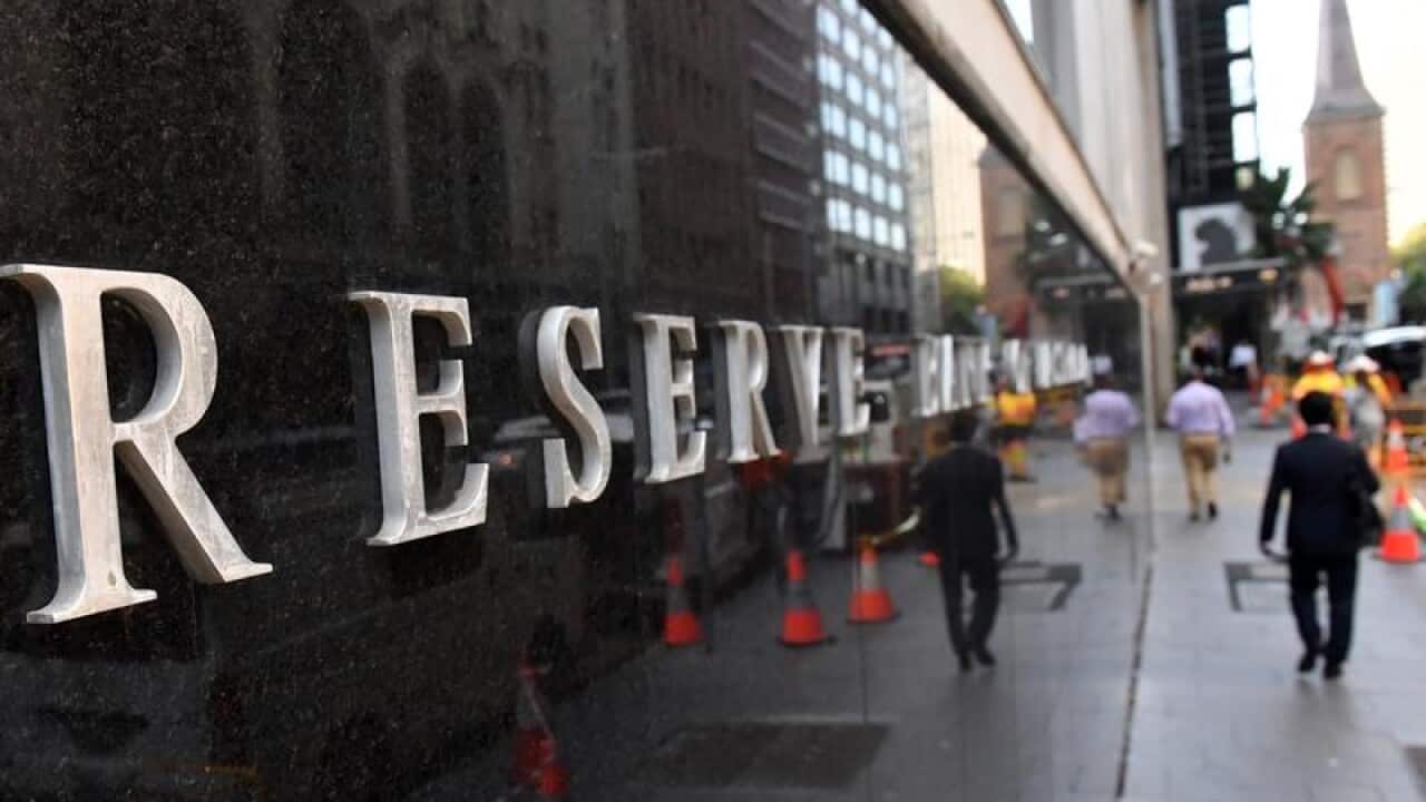 A pedestrian walks past the Reserve Bank of Australia in Sydney