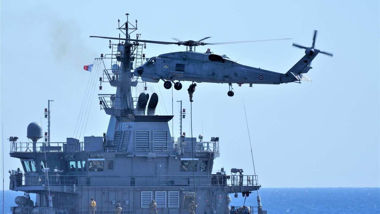 A military helicopter loads marines over a naval ship during an annual NATO naval exercise on Turkey's western coast on the Mediterranean, Thursday, Sept. 15, 2022.