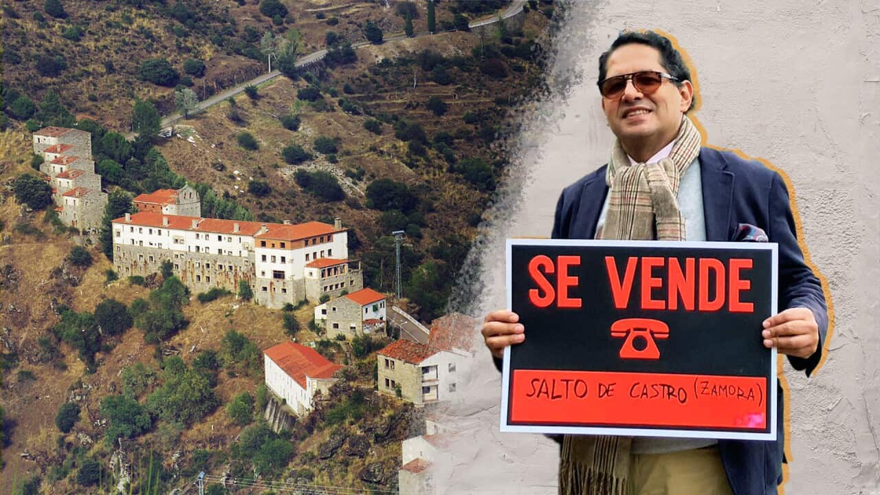 A town in Spain and a man holding a sign.