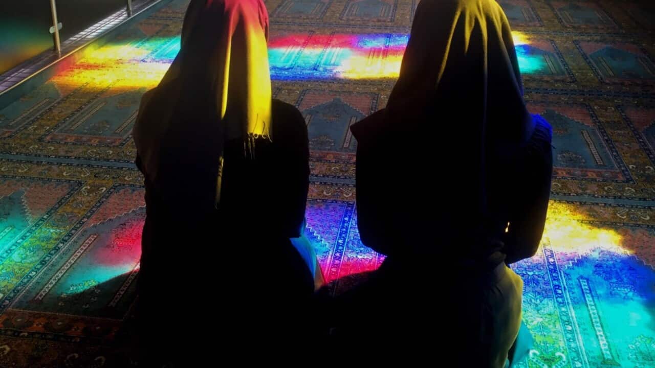 Two Muslim women sit side-by-side