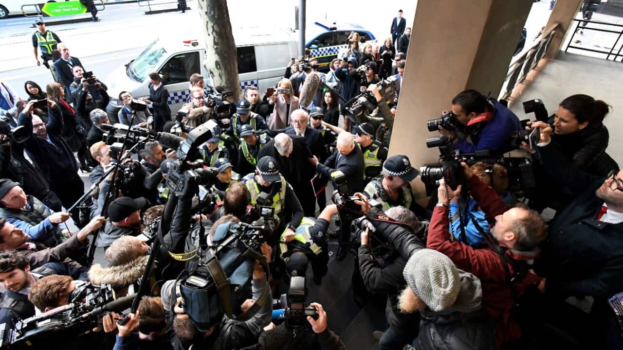 Cardinal George Pell escorted by police departs the Melbourne Magistrates Court in Melbourne, Wednesday, July 26, 2017 (AAP)