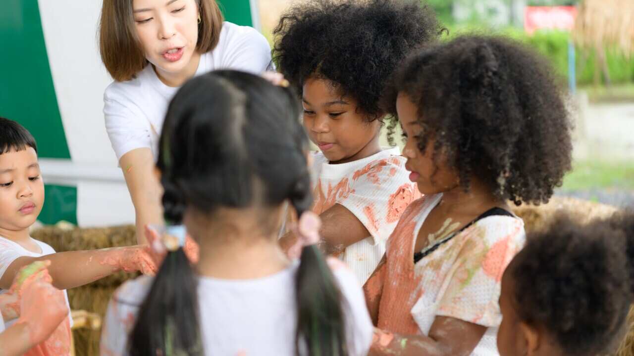 Children have fun playing with colors. They are holding hands