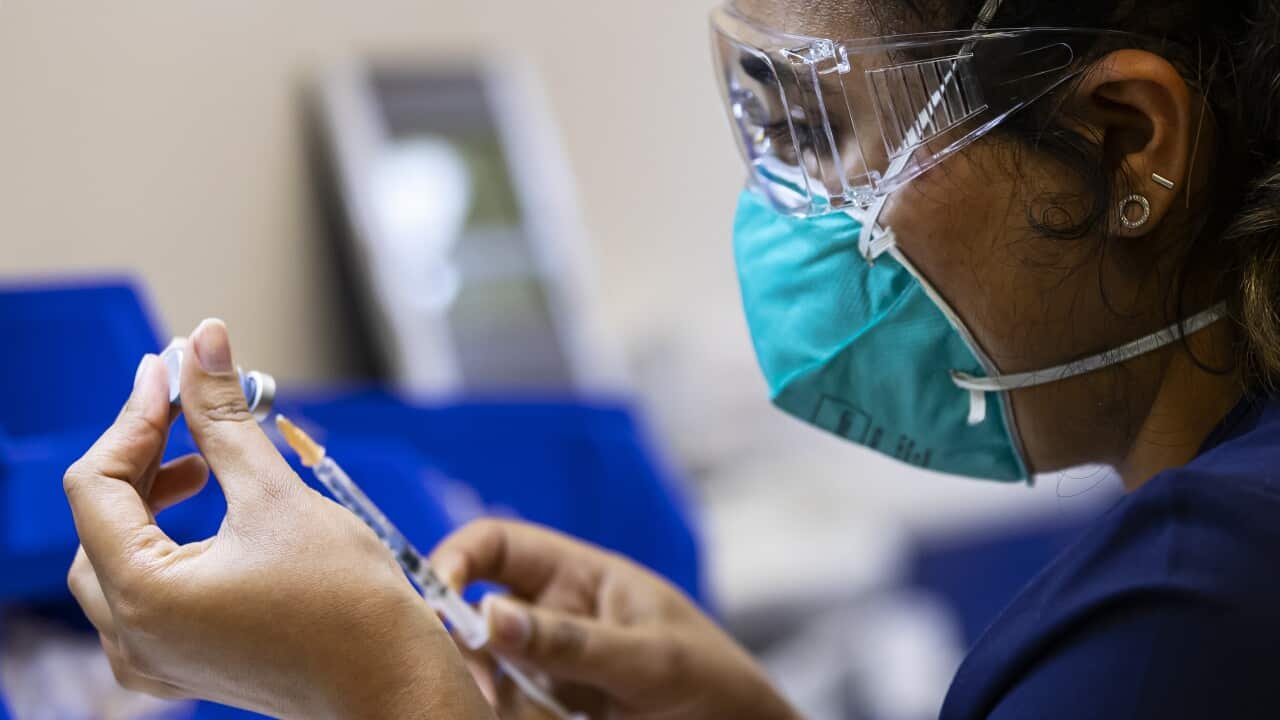 A healthcare worker preparing to administer a COVID-19 vaccine.