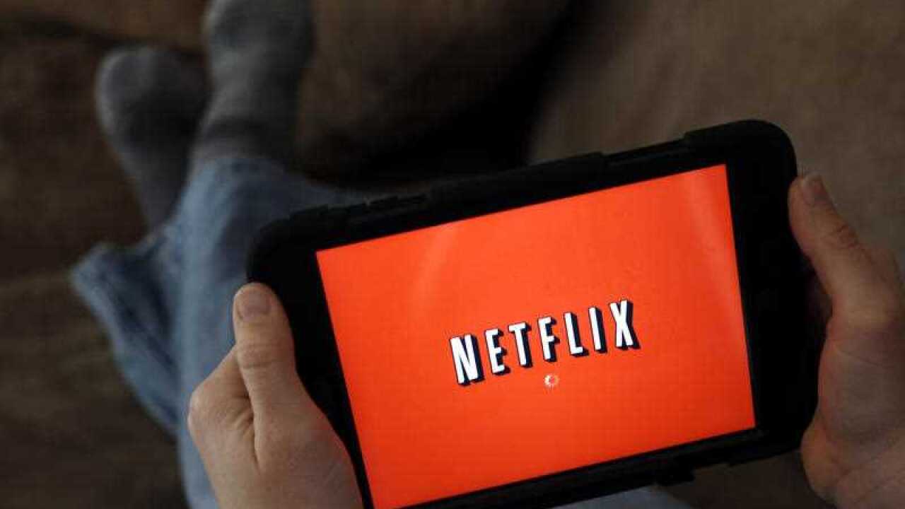 A person displays Netflix on a tablet in North Andover, Mass.
