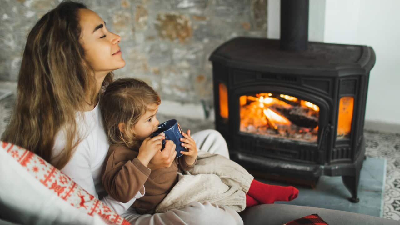 Happy family resting near fireplace at home.