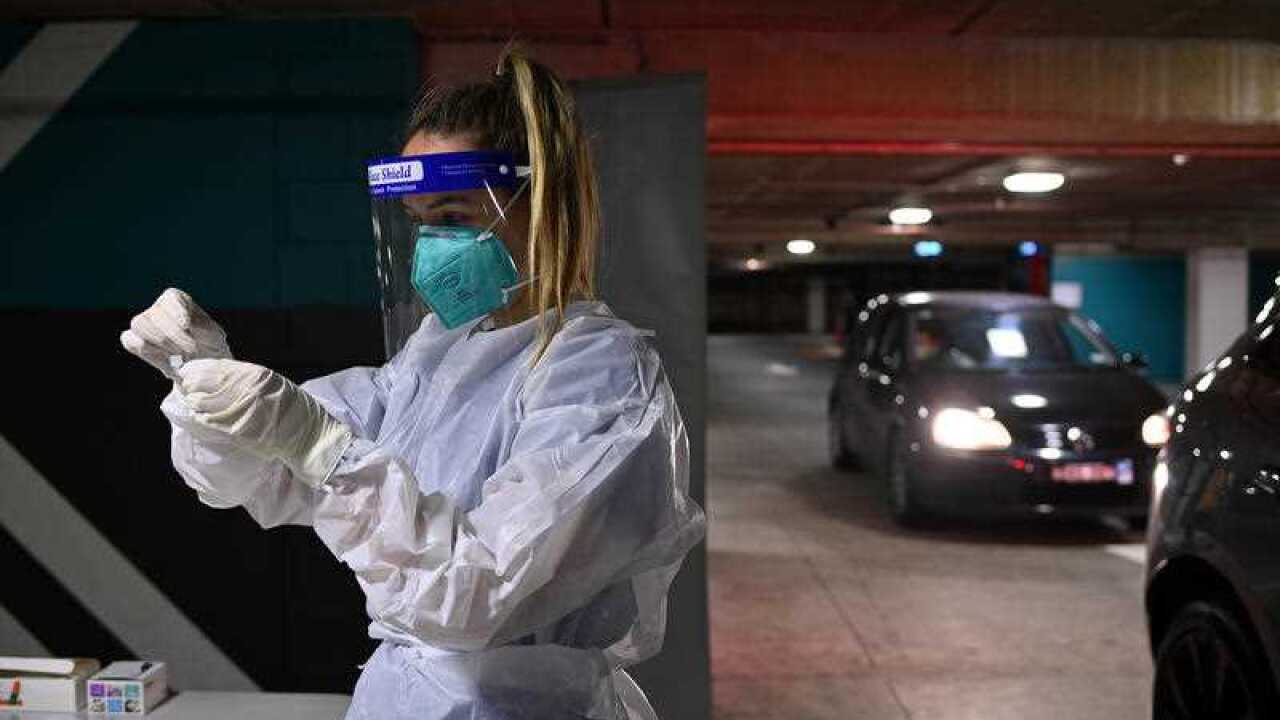 A nurse performs a COVID-19 Rapid Antigen Test at a drive-through testing facility at the Royal Randwick shopping centre car park in Sydney.