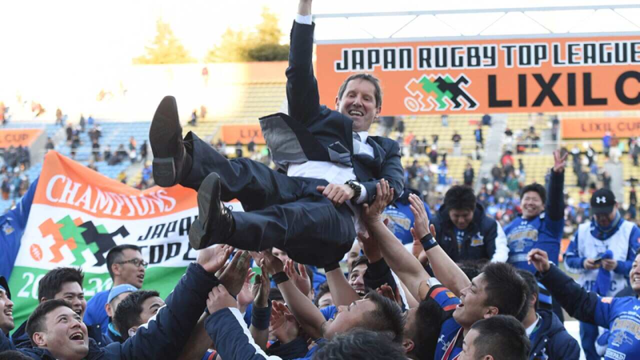 coach of Panasonic Wild Knights is tossed up in the air by his players