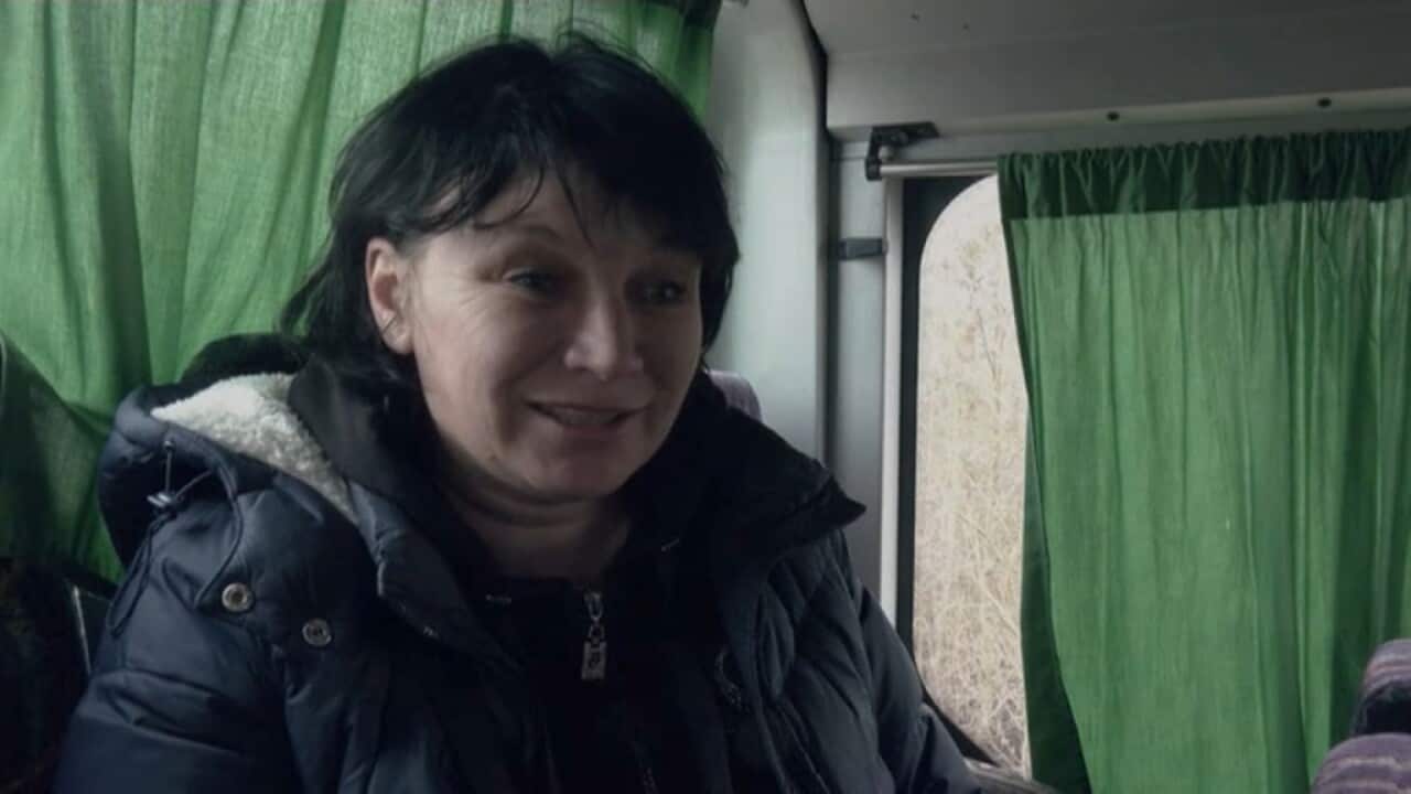 Mother Natalia Rakk wears a black jacket while being interviewed inside a bus after being reunited with her daughters.