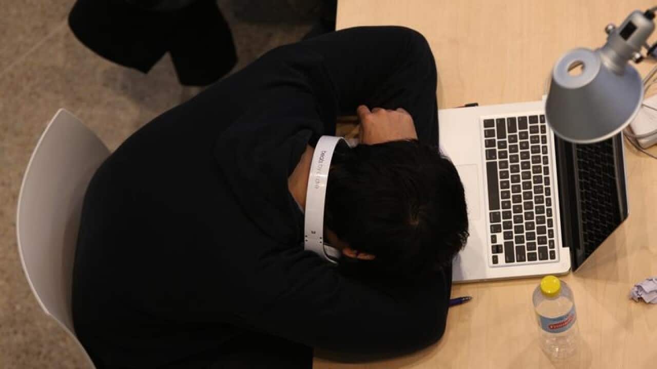 A man sleeps on his laptop at the State Library of NSW