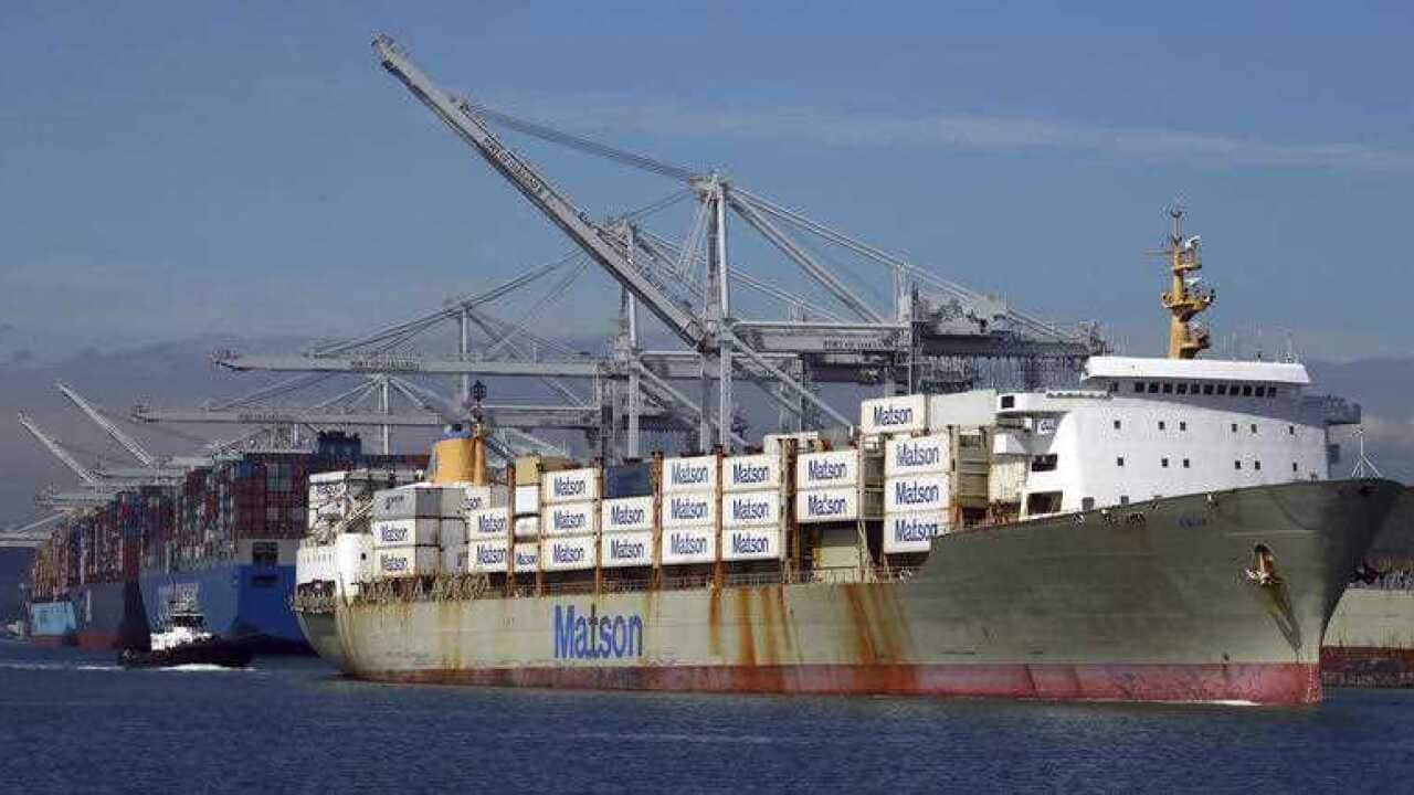 a tugboat assists a container ship in docking at the Port of Oakland in Oakland, California.