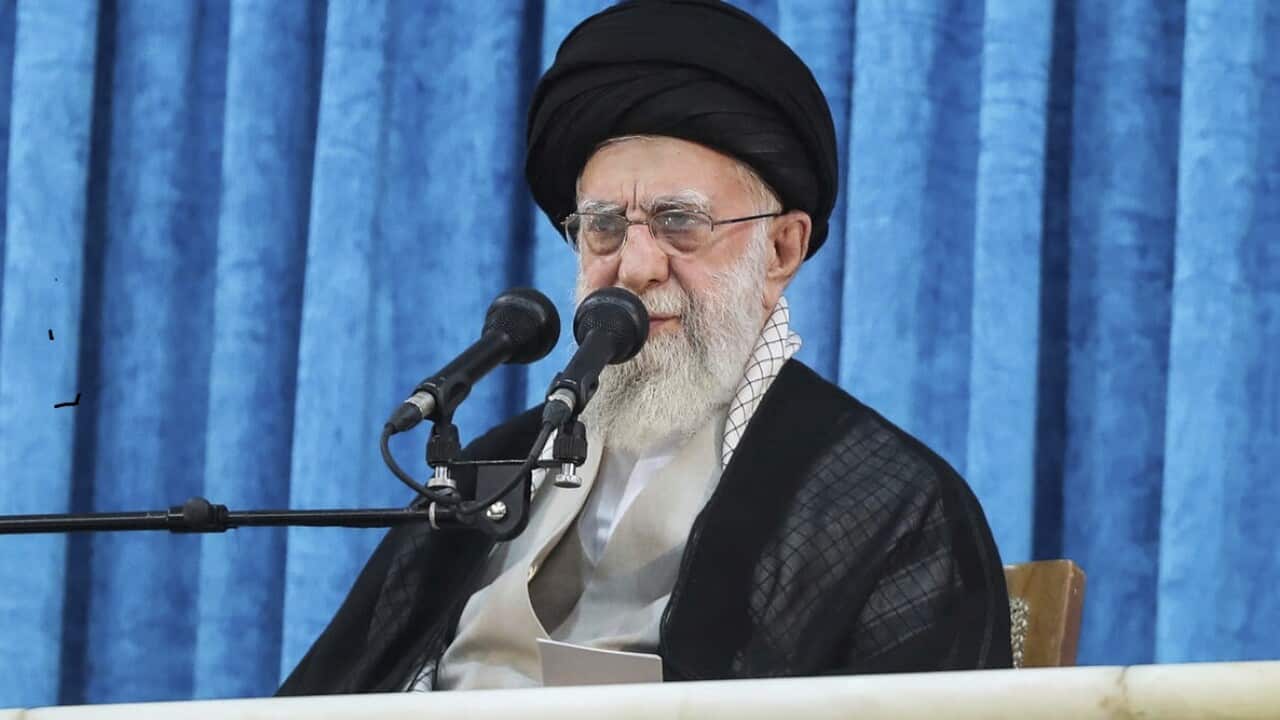 Ayatollah Ali Khamenei speaking in front of a microphone.