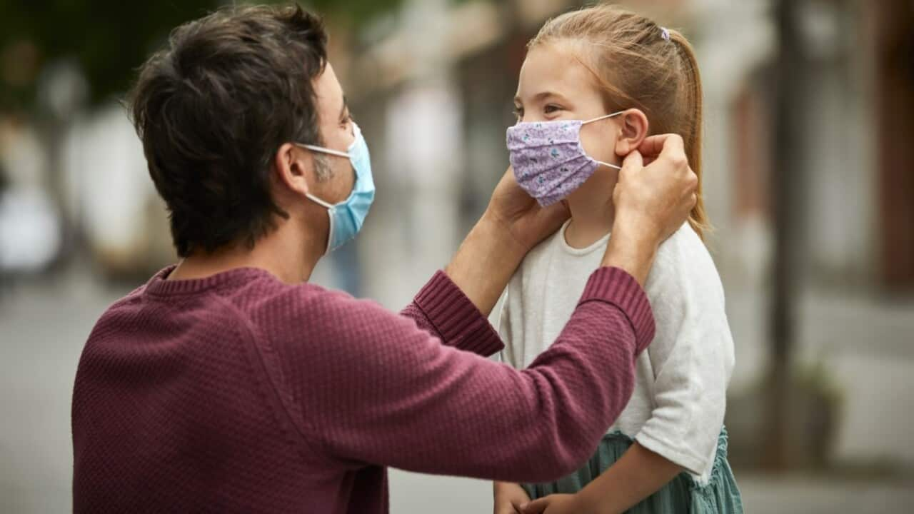 Father helps daughter with mask -  Getty Images - Morsa 