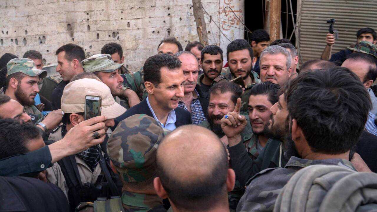 Syrian President Bashar Assad, center left, speaks with Syrian troops during a visit to the front line in the newly captured areas of eastern Ghouta.