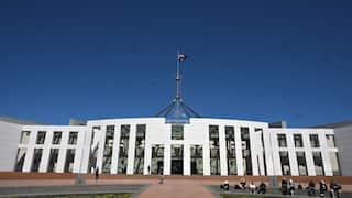 Australian Parliament House in Canberra, with the national flag flying above the building.