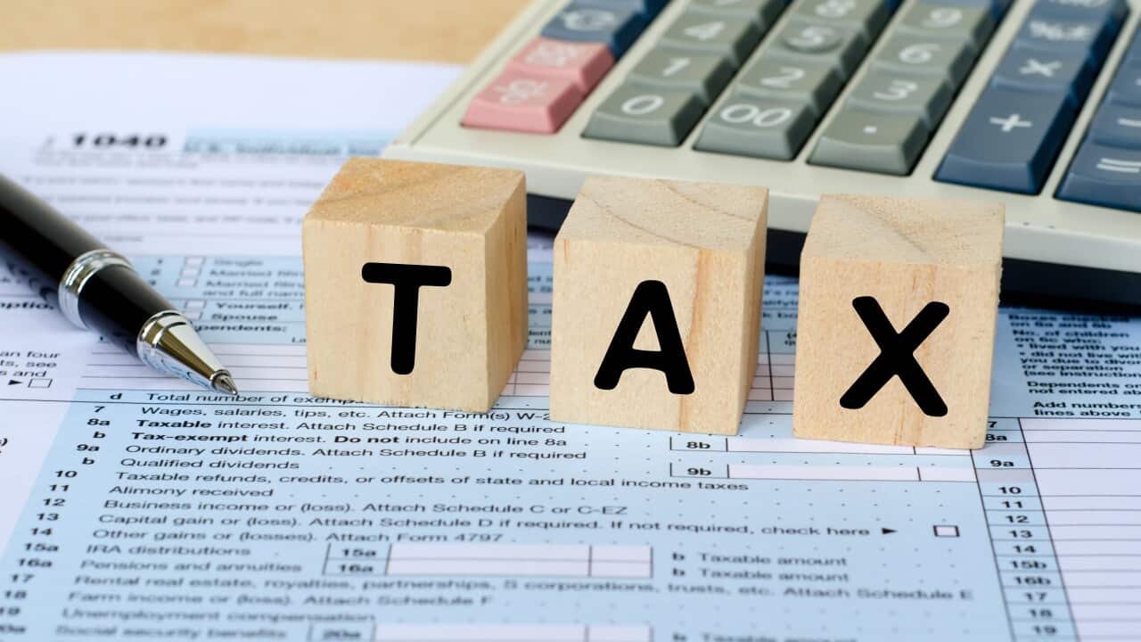 Tax Word on Wooden Block With Calculator and Tax Form