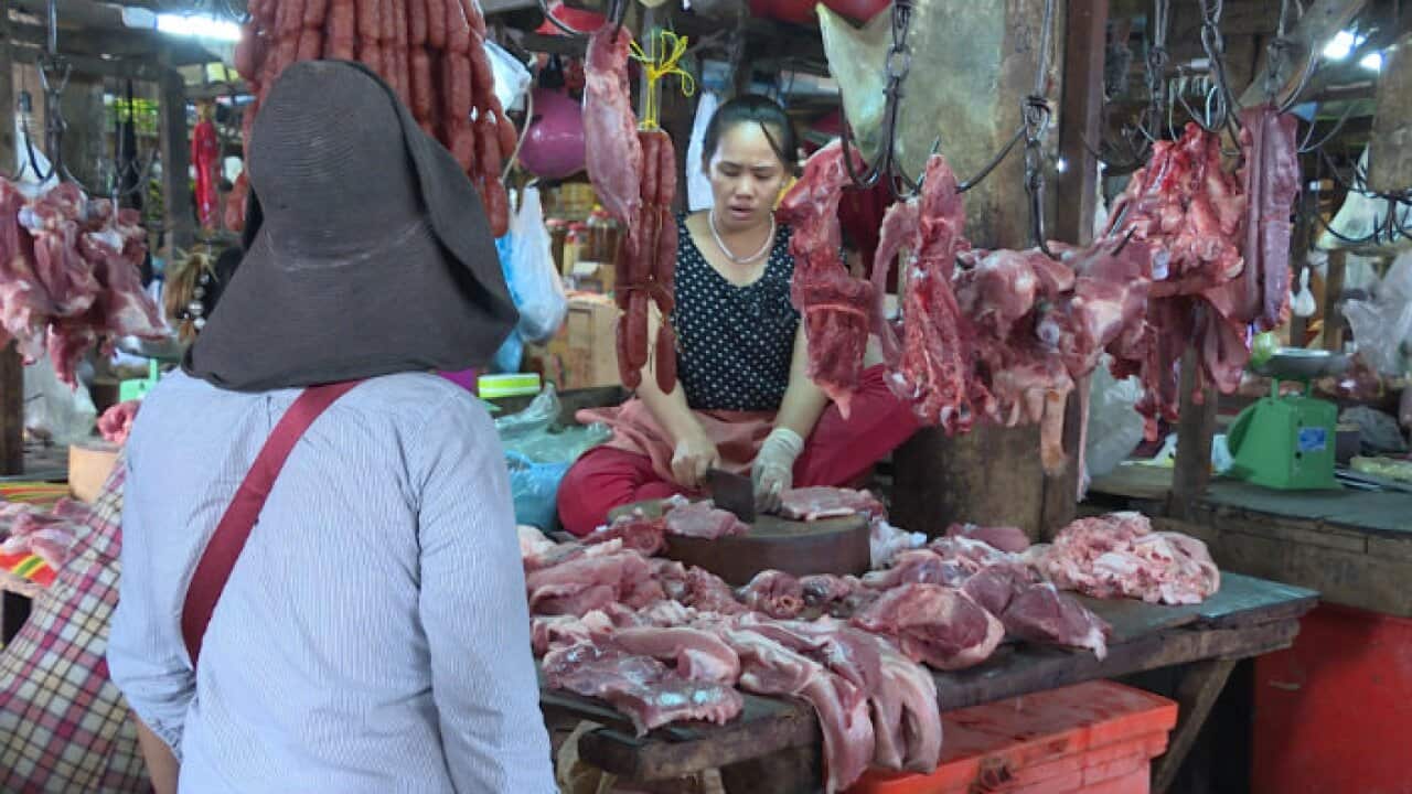 People buying pork in market in Phnom Penh