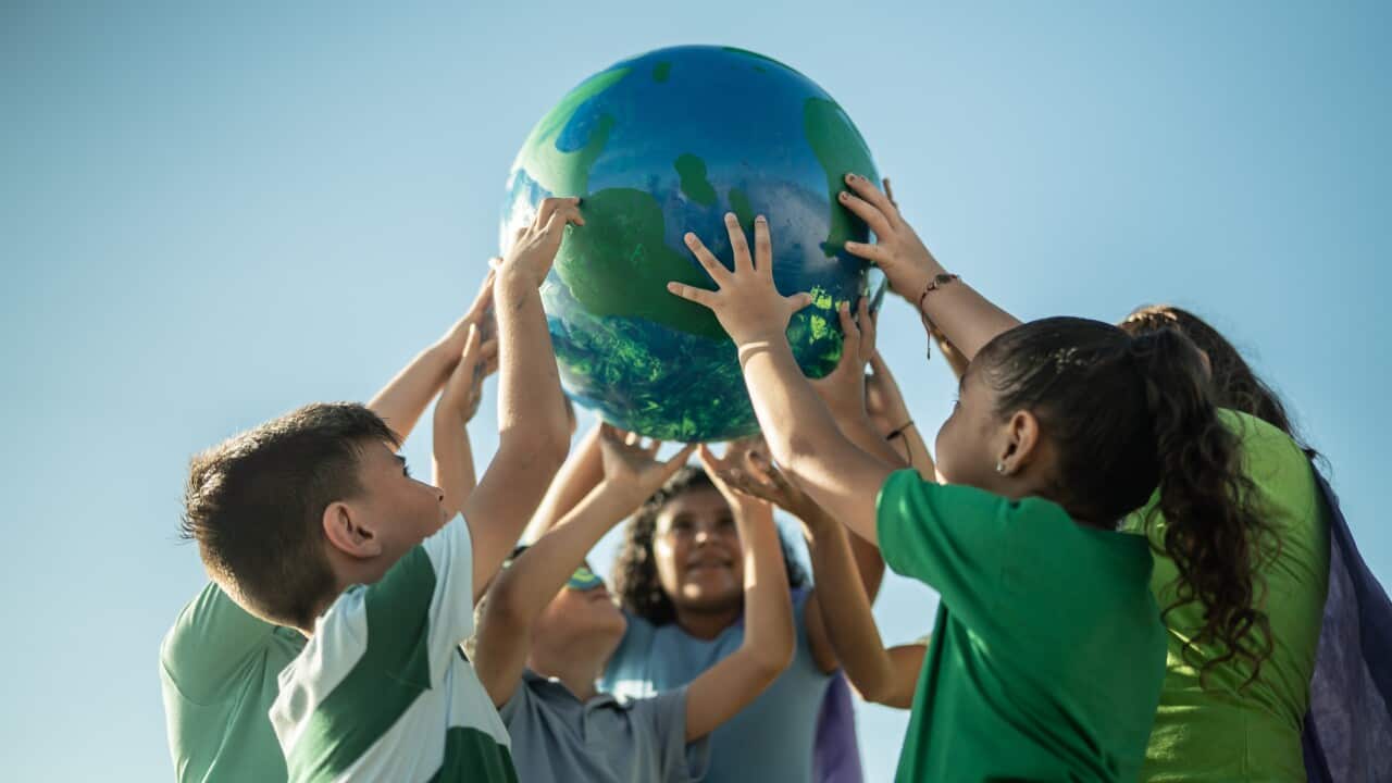 Children holding a planet outdoors