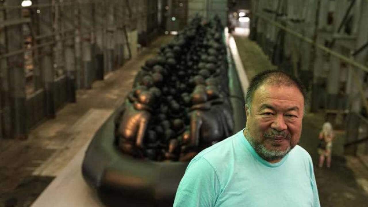 : Ai Weiwei poses in front of his installation Law of the Journey in Sydney