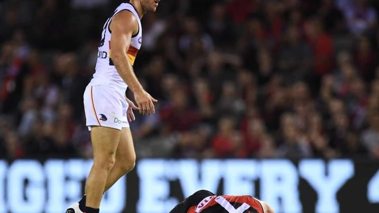 A file image of AFL player Richard Douglas standing over Zach Merrett.