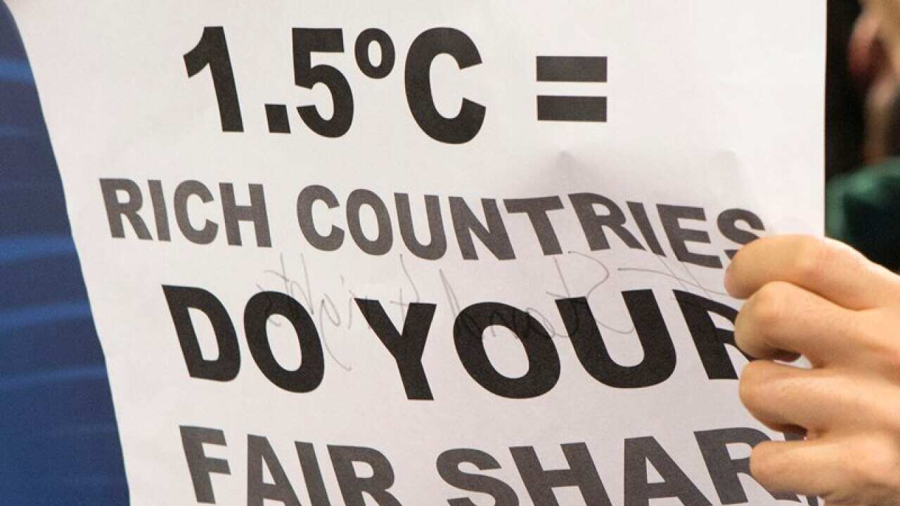 A protester holds a sign during a protest at the COP21 summit