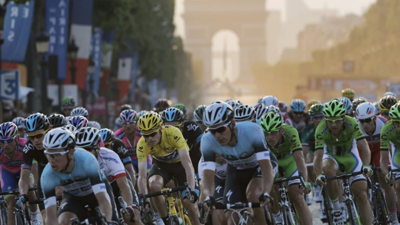 Cyclists speed down Champs Elysees during the Tour de France