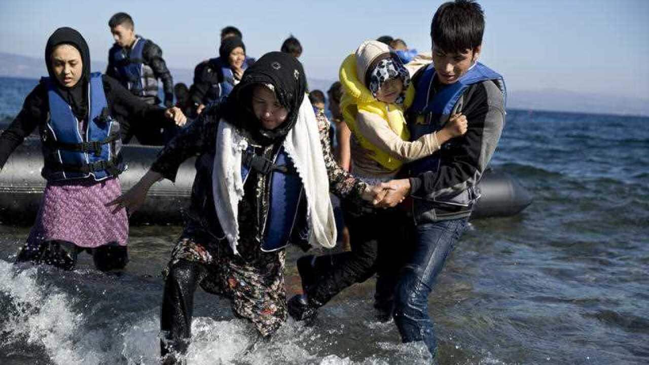 Migrants arrive aboard a dinghy after crossing from Turkey, on the island of Lesbos, Greece.