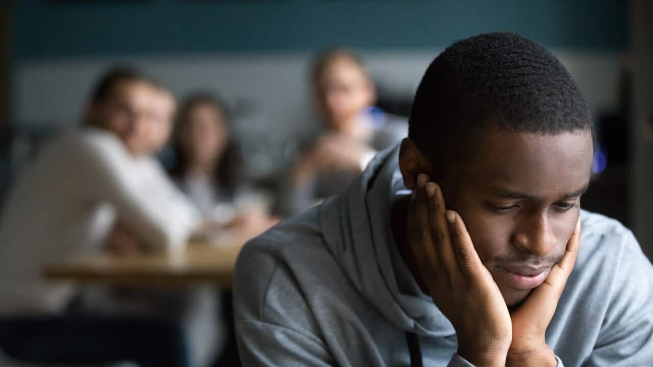 Black guy sit alone in cafe suffering from racial discrimination