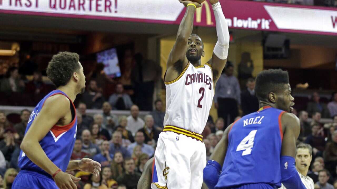 Cleveland's Kyrie Irving (C) shoots against Philadelphia