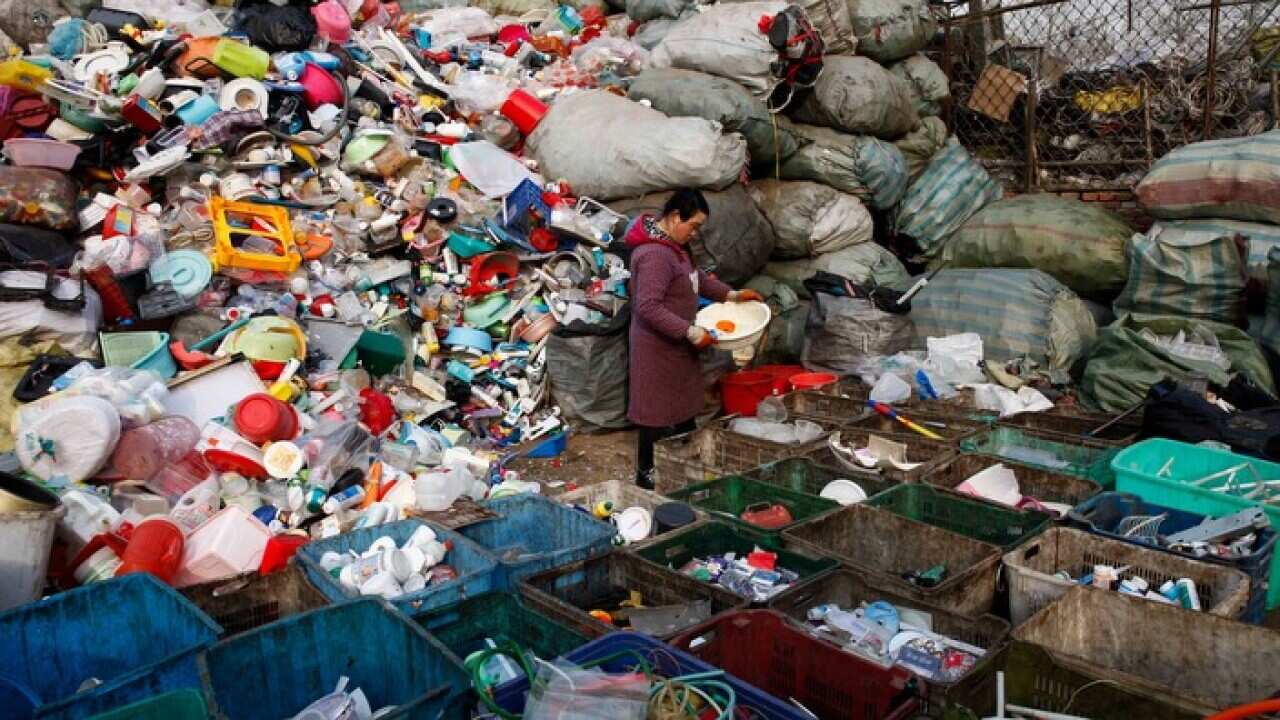 A worker sorts used plastics at a dump in Changping district of Beijing, China