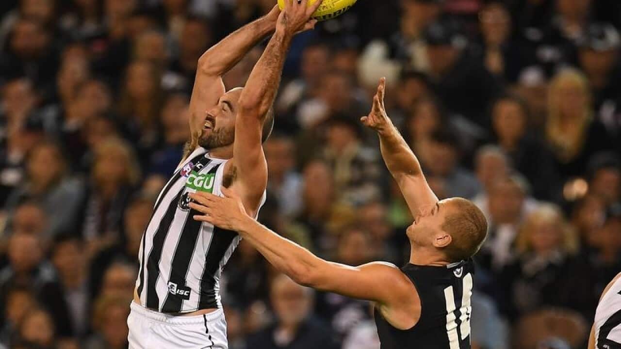 Steele Sidebottom of the Magpies catches the ball.