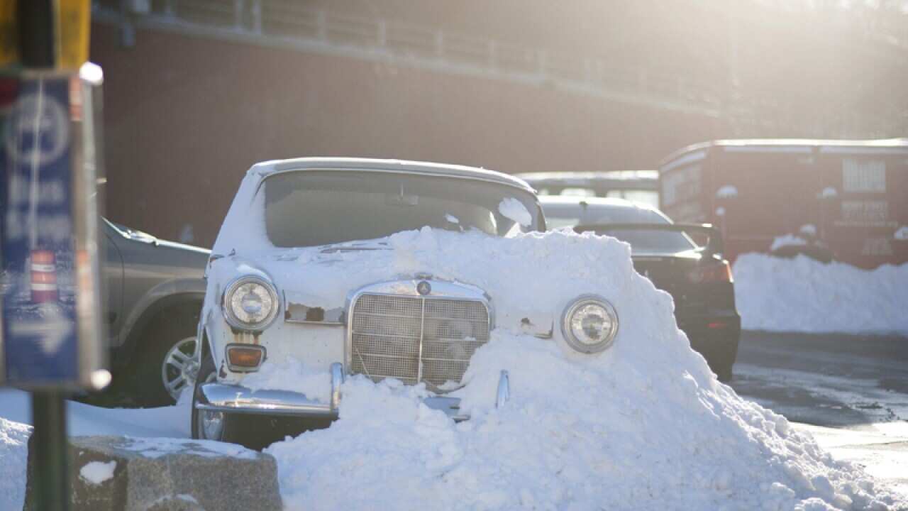 A car covered in snow is seen parked at a parking space in NY, USA