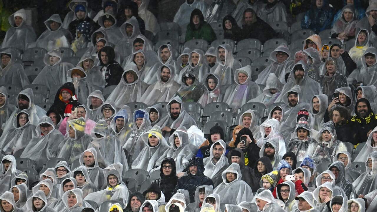 Members of the crowd during rain during the AFL Round 14 match between the Richmond Tigers and the St Kilda Saints at the Melbourne Cricket Ground in Melbourne, Saturday, June 17, 2023.