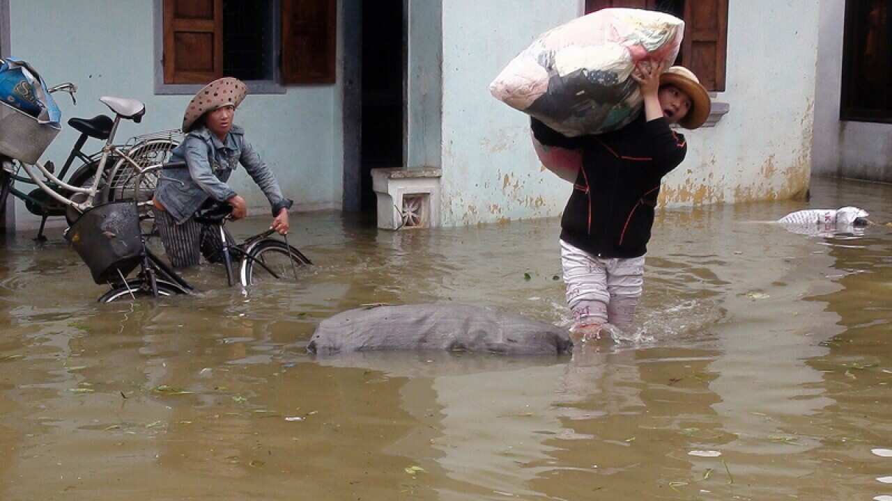 Residents move their belongings from a flooded house in Vietnam