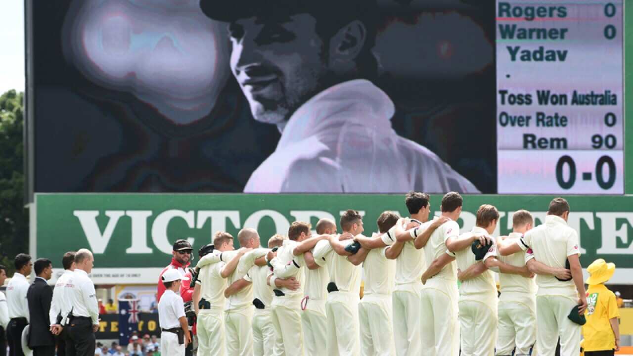 The Australian team with an image of Phil Hughes