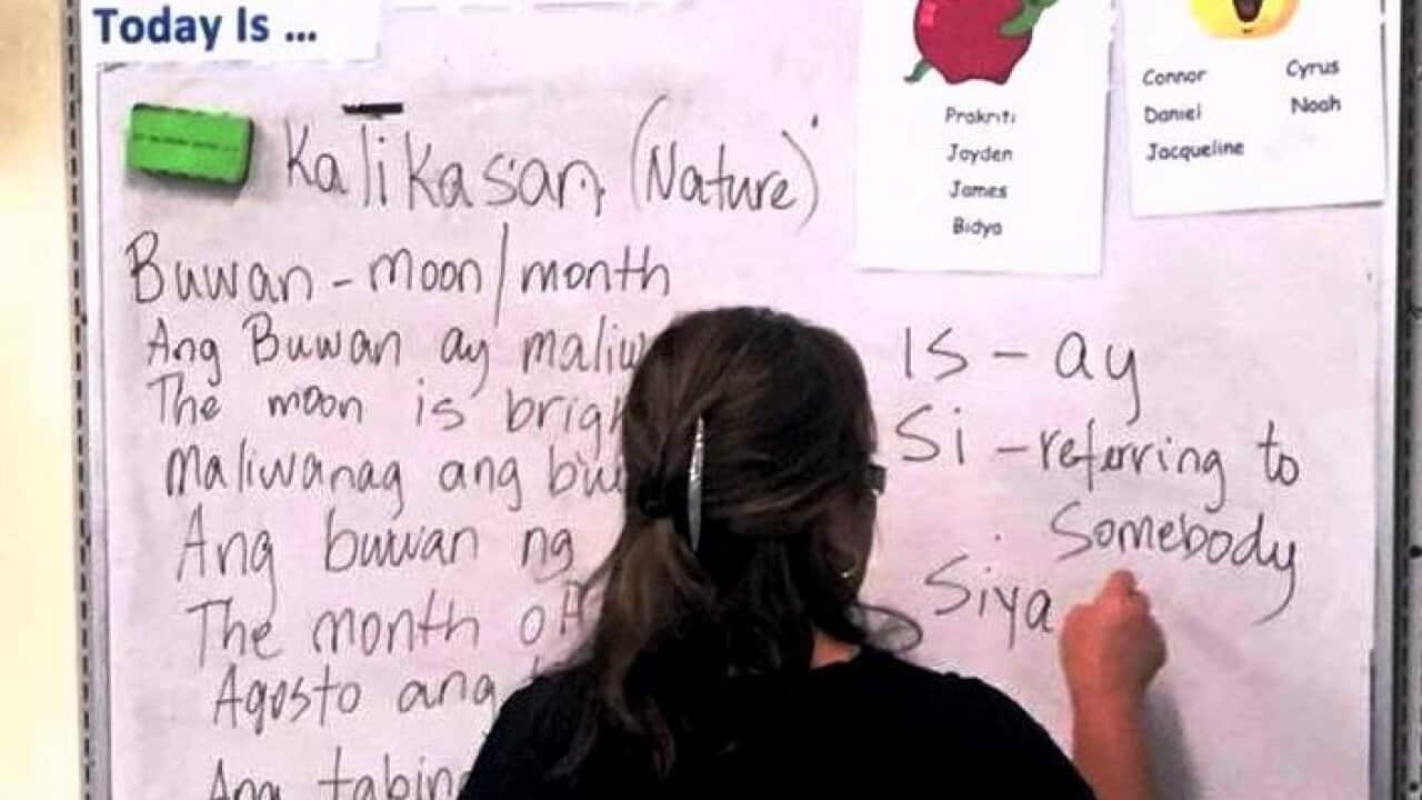 Filipino language teacher writing on the whiteboard 
